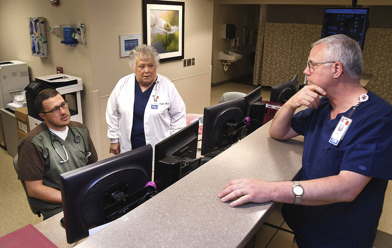 Dr. Timothy Lane, left, talks with Debbie Vaughn, Chief Nursing Office, second to left, and Dan Shelford, Assistant Chief Nursing Officer in the ER at Raleigh General Hospital.  Photo by Rick Barbero, The Register Herald